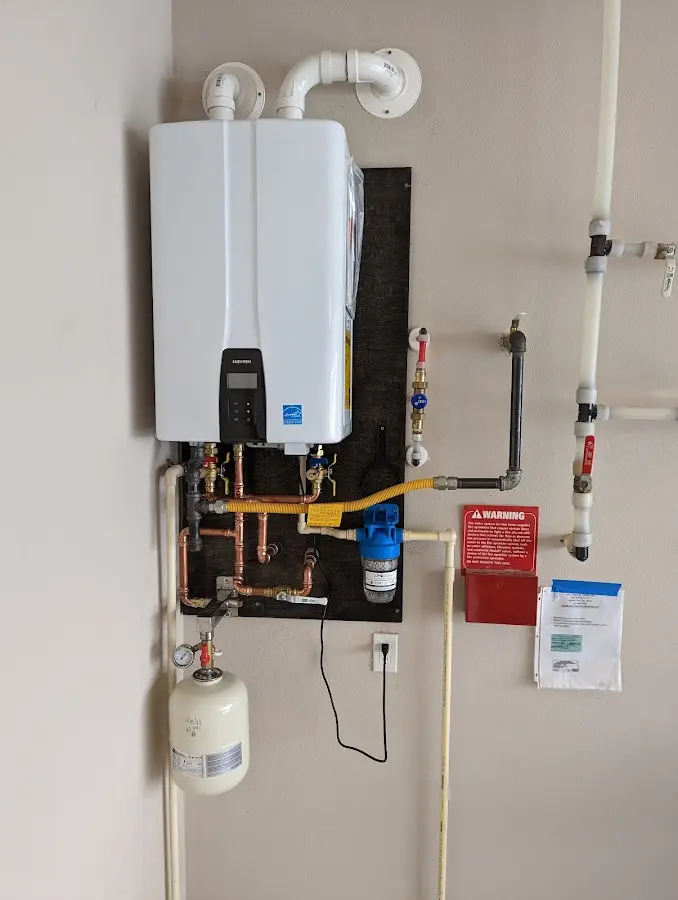 Professional plumber installing copper piping in a Bogota home